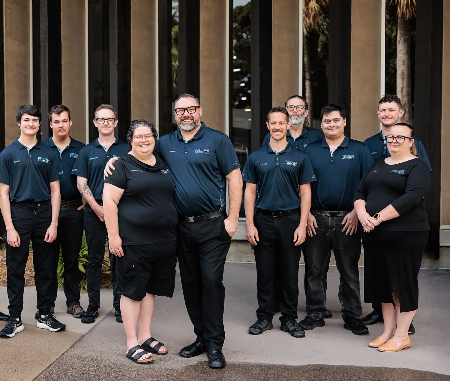 The TranTech crew standing together outside in Mackay, wearing navy TranTech shirts